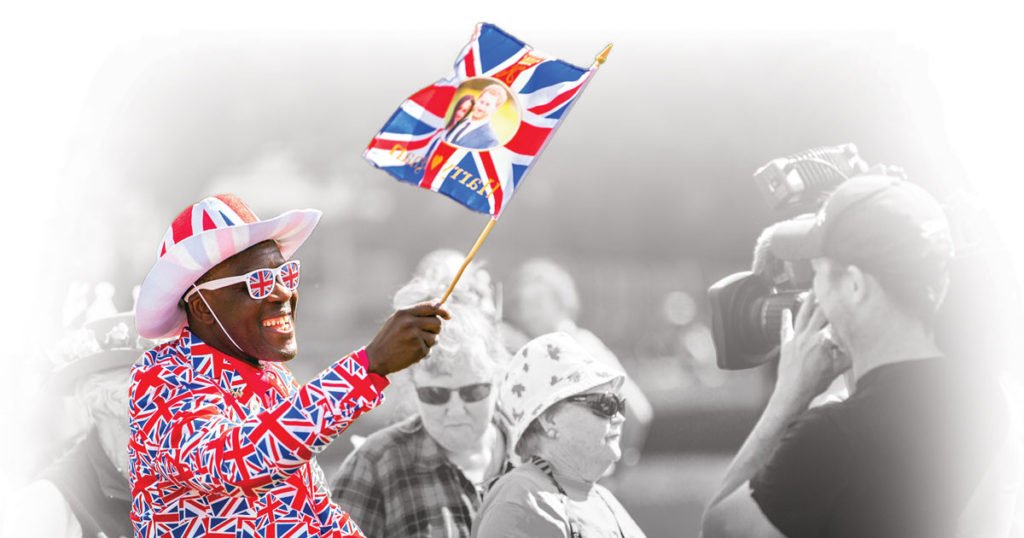 man waiving england flag with royal couple